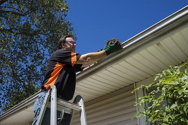 two workers fixing a gutter on a residential house in Addison, IL